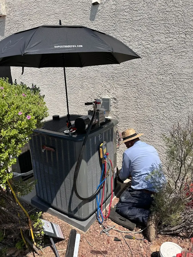 HVAC technician performing outdoor AC maintenance in Claiborne