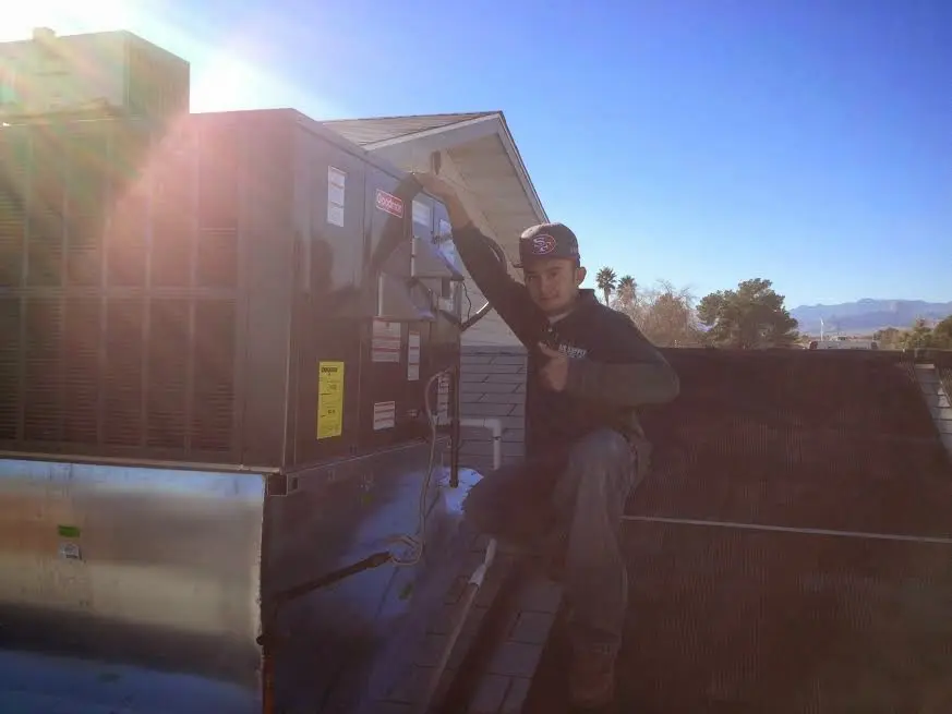 HVAC technician performing HVAC Inspection on a rooftop unit in Claiborne